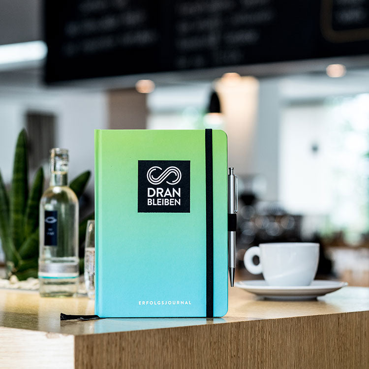 DRANBLEIBEN Erfolgsjournal steht auf Theke